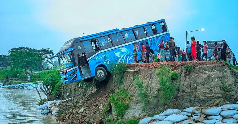 নদীর পাড়ে ঝুলে পড়া যাত্রীবাহী বাস